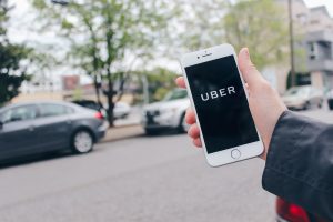 Man holding phone displaying Uber app