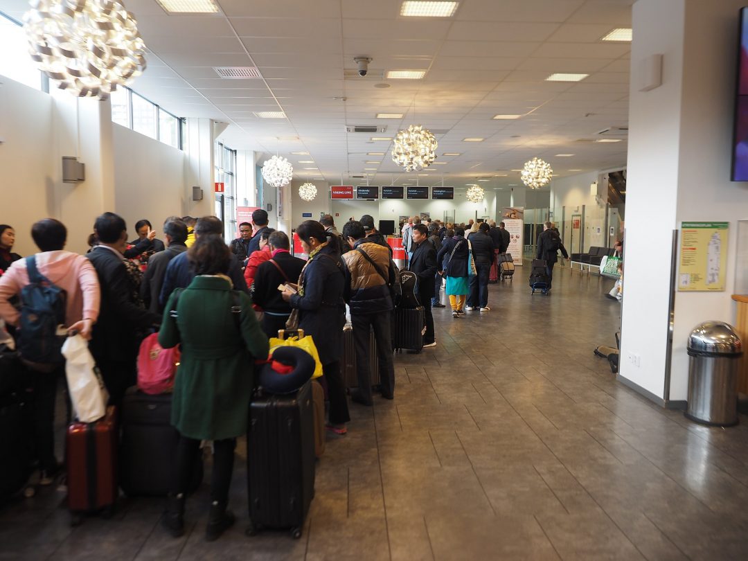 A queue of people at an airport terminal.
