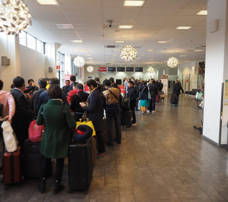 A queue of people at an airport terminal.