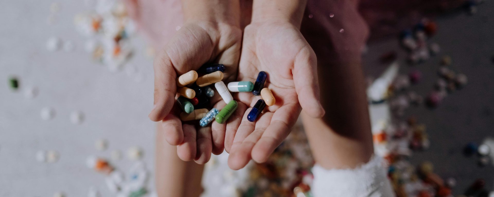 A hand holding out pills