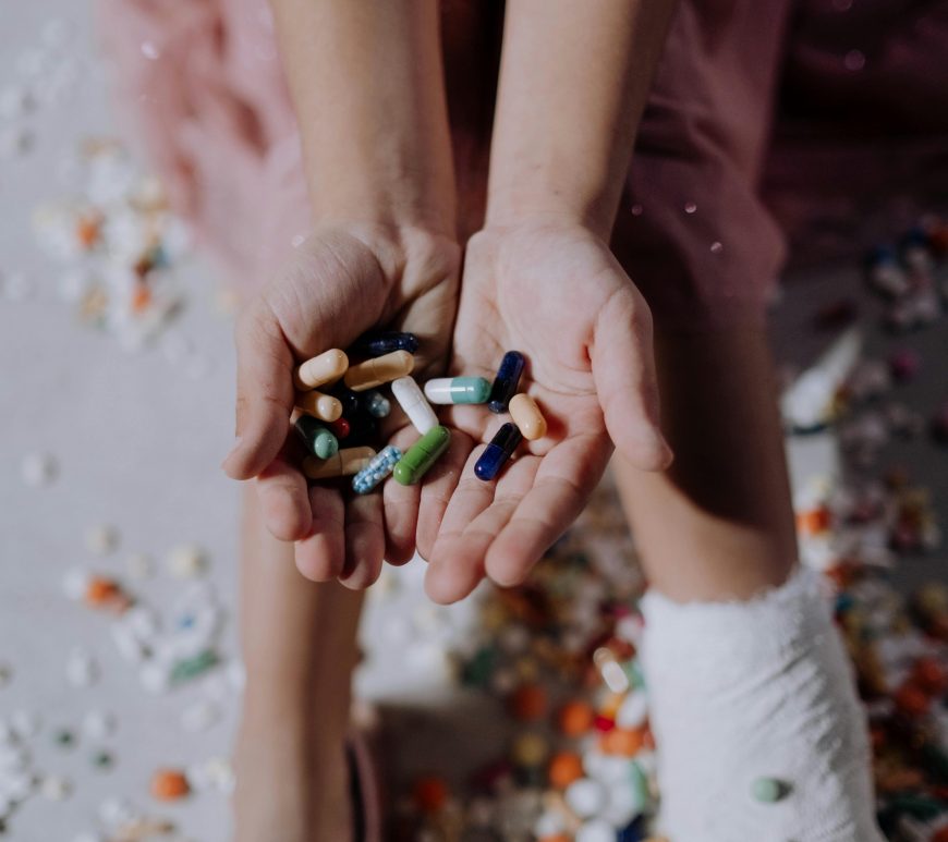 A hand holding out pills