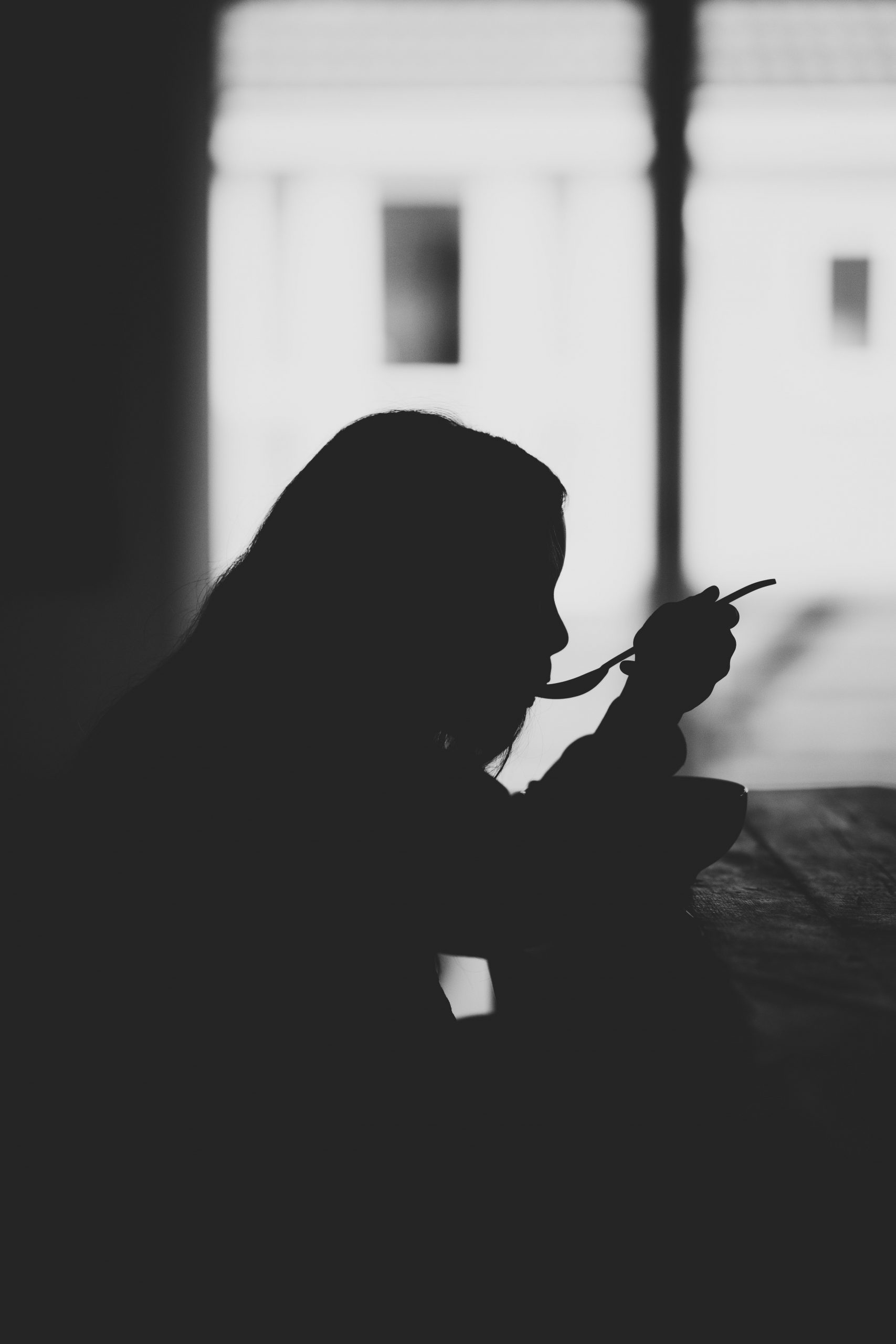 Black & White Image of a Girl Eating Alone. Image by Annie Spratt on Unsplash