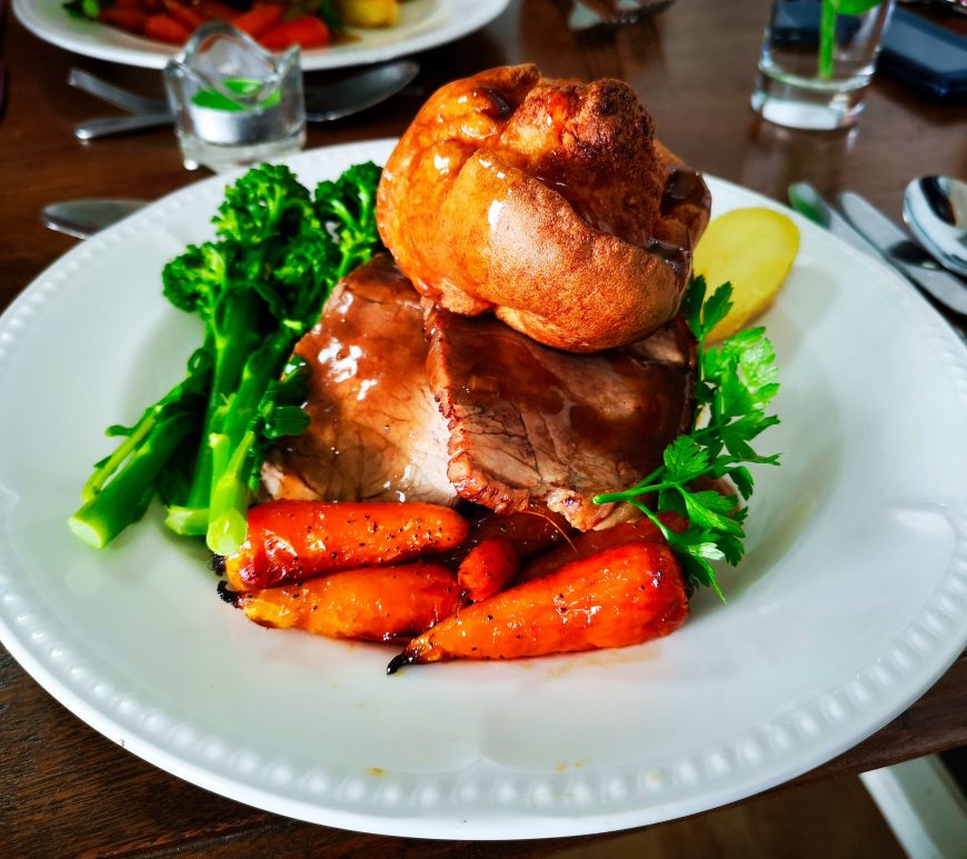 A Sunday roast with carrots, Yorkshire pudding, broccoli and gravy