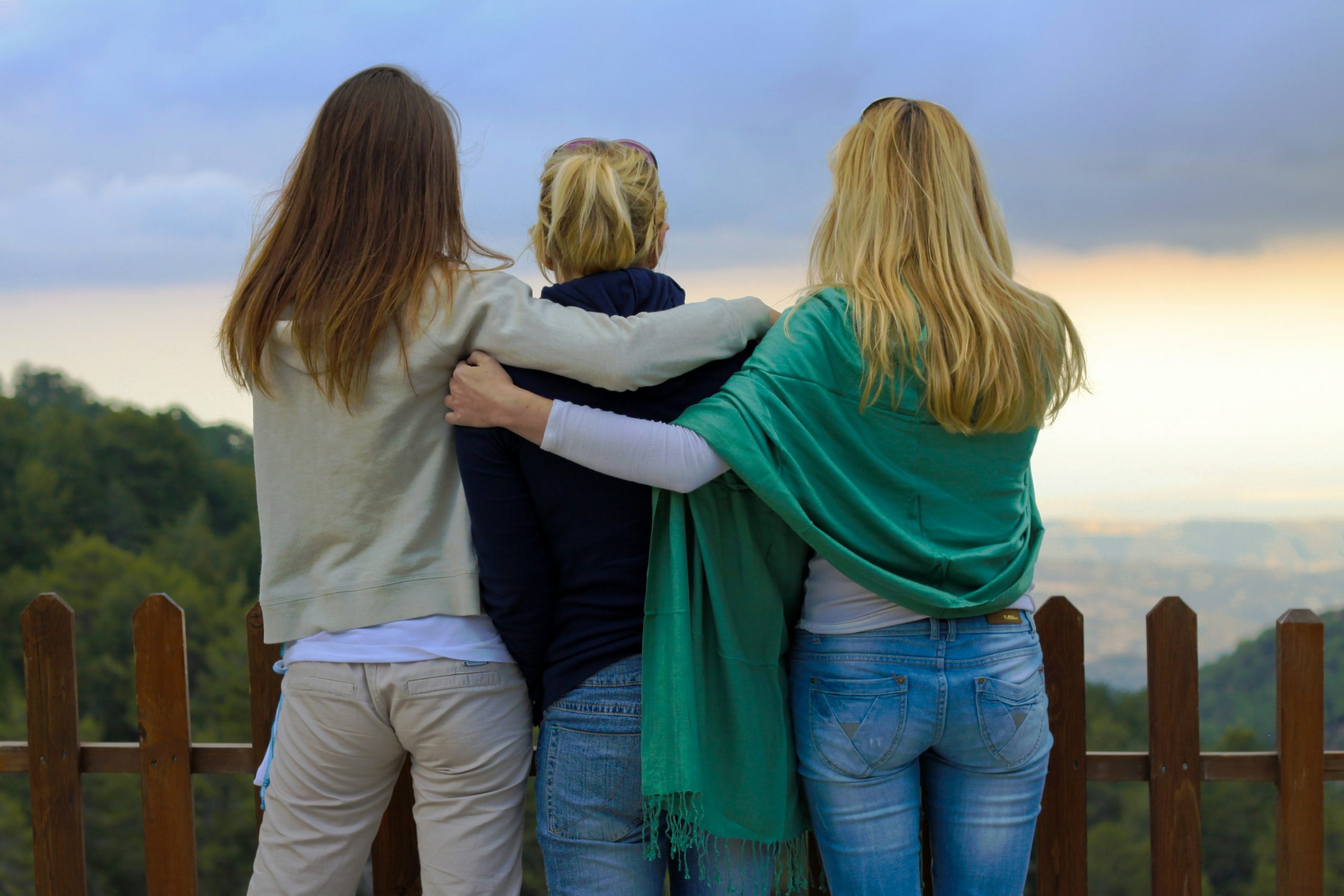 three women embracing, watching the sunset