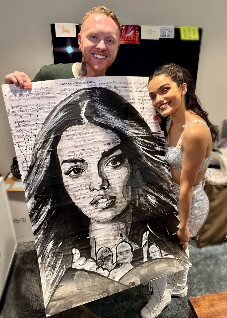 Nathan Wyburn presenting Rachel Zegler with her pop art portrait
