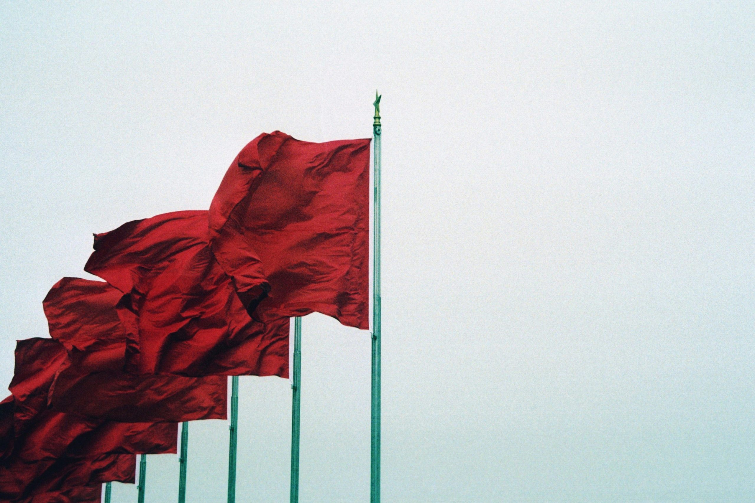 Six red flags over a white background