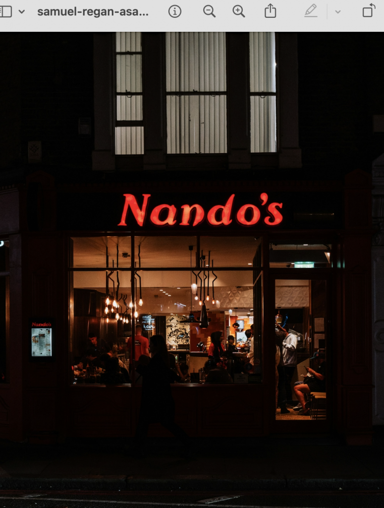 Nando's shopfront and neon sign at night