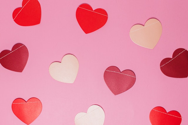 10 red & pink hearts over a pink background