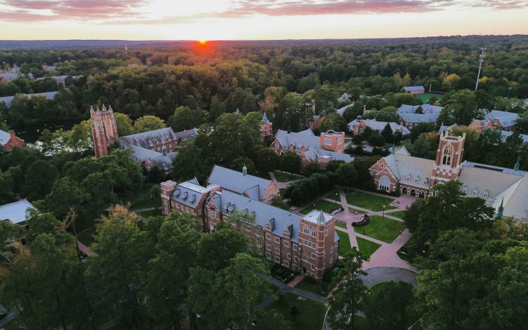 Red building college campus surrounded by trees