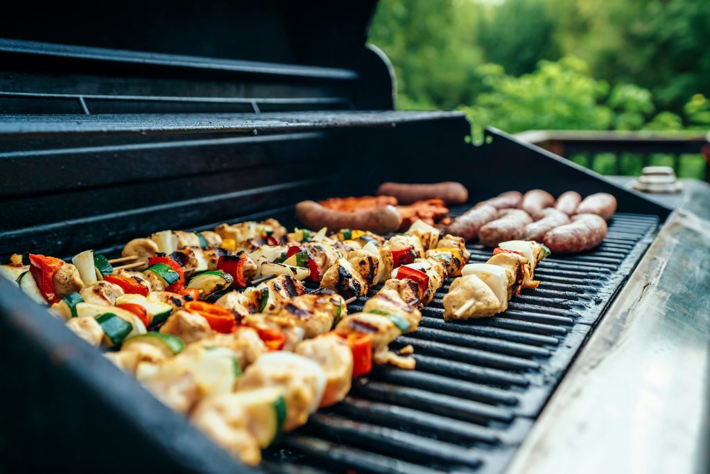 Chicken skewers and sausages on a barbecue