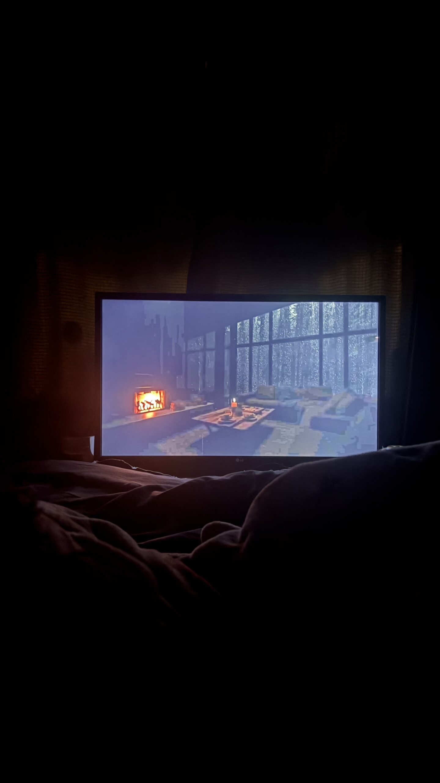 The image shows a cosy room with a tv and candles